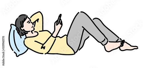 寝転がってスマホを見ている女性
