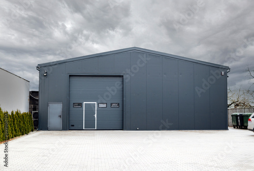 Metallic black garage with roller doors, industrial warehouse.