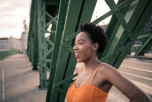 Profile of a black girl on the bridge in a European city 