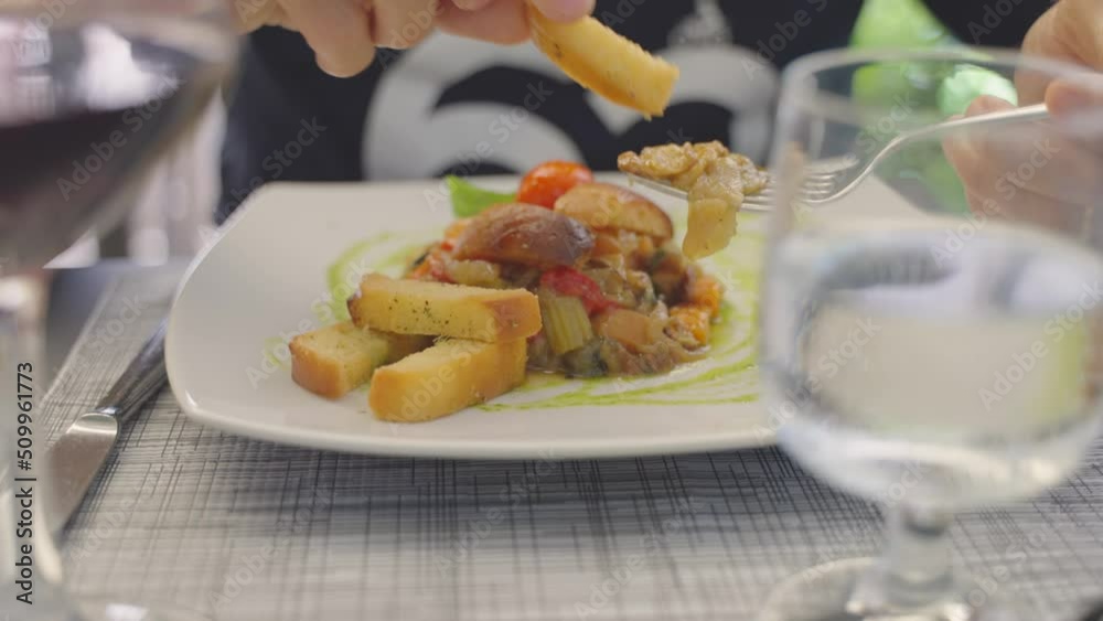 Closeup of man eating a delicious dish of caponata, a vegetarian traditional Sicilian food.
Closeup of man eating a delicious dish of caponata, a vegetarian traditional Sicilian food.