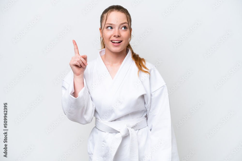 Young caucasian girl doing karate isolated on white background thinking an idea pointing the finger up Young caucasian girl doing karate isolated on white background thinking an idea pointing the finger up