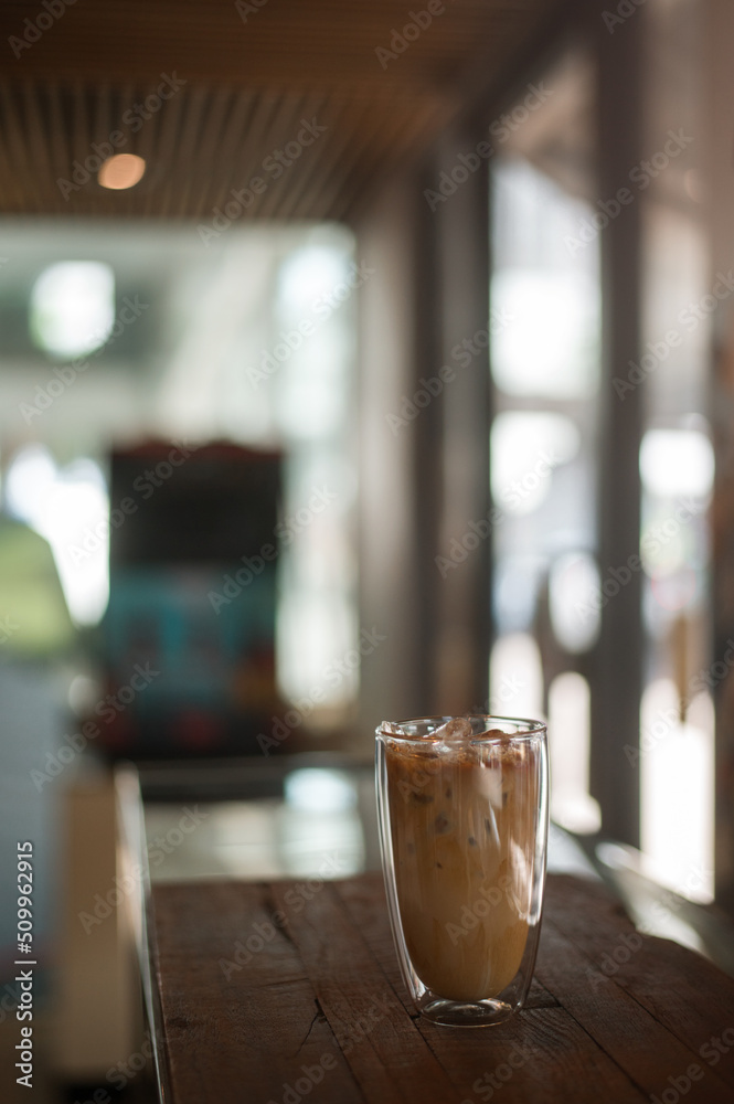 Ice coffee on a table with cream being poured into it showing the texture and refreshing look of the drink Ice coffee on a table with cream being poured into it showing the texture and refreshing look of the drink