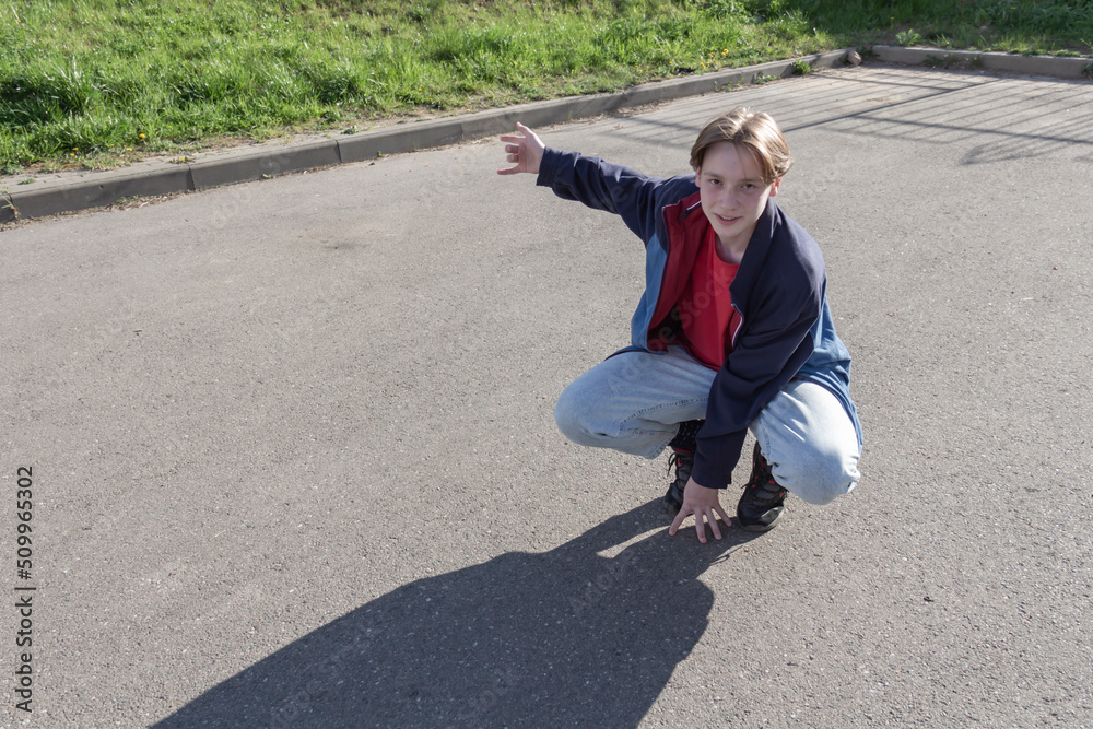 Fototapeta premium A teenager, a young man passionate about modern dancing dances alone on the street, in the fresh air.