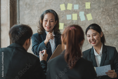 Senior businesswoman with senior executives talking in a meeting, she is meeting with department head staff at a conference room, senior female executives and new generation employees working together