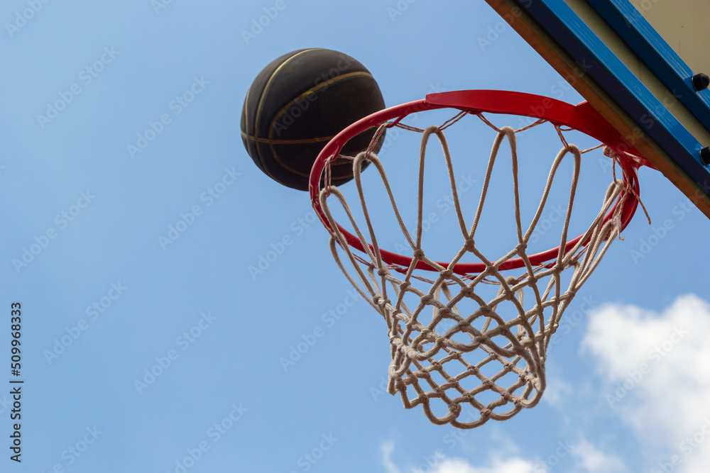 A basketball in the net. The fly ball is in the ring. A sports game. Conceptual: victory, success, hitting the target, sport. Successful ball throw