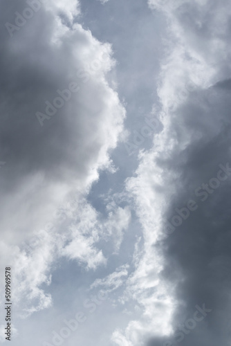 Two grey clouds passing each other with gap in middle, bright edge and dark center of cloud