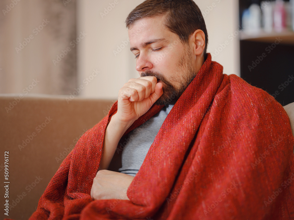 Coronavirus. Sick man of corona virus lying down in sofa and recovery from illness in home. Blowing his nose. The concept of high temperatures. The person is seriously ill. Coronavirus. Sick man of corona virus lying down in sofa and recovery from illness in home. Blowing his nose. The concept of high temperatures. The person is seriously ill.