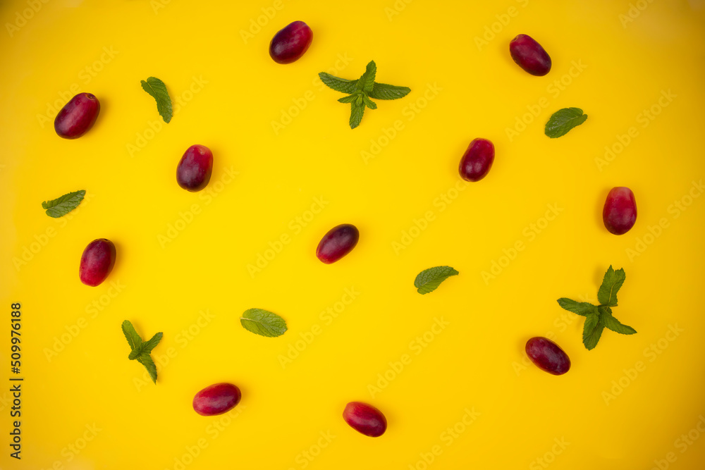 group of fresh and tender red grapes on a pastel yellow background accompanied by mint leaves group of fresh and tender red grapes on a pastel yellow background accompanied by mint leaves