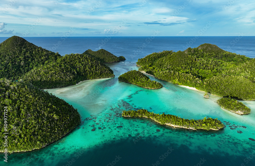 Aerial view of scattered islands with blue ocean water at Wajag Island, Raja Ampat, West Papua, Indonesia. Aerial view of scattered islands with blue ocean water at Wajag Island, Raja Ampat, West Papua, Indonesia.