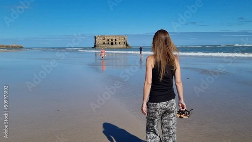 Elegant beautiful girl overlooking the bay in .Tarfaya,, Marroco 4K videos. walking along the sandy beach. photo