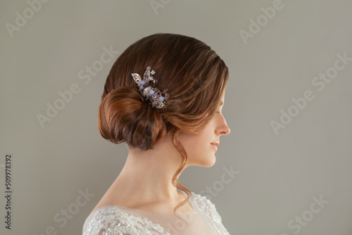 Beauty wedding hairstyle decorated with jewelry on female head, rear view