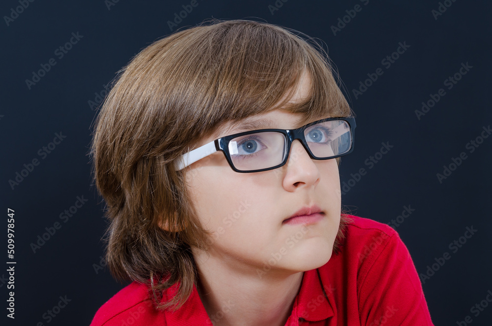 Teenager in red t-shirt and glasses is looking up Teenager in red t-shirt and glasses is looking up