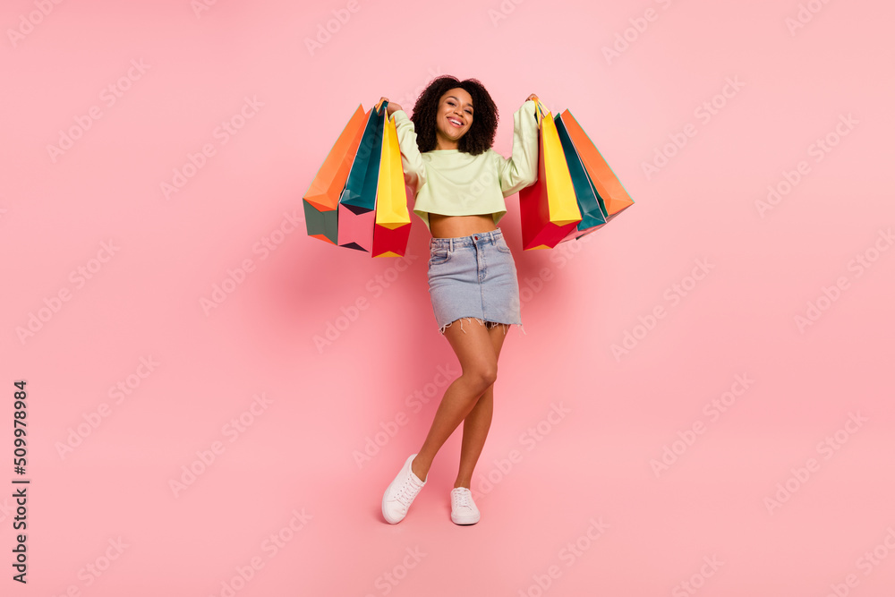 Full size photo of young pretty cheerful girl enjoy shopping store isolated over pink color background Full size photo of young pretty cheerful girl enjoy shopping store isolated over pink color background