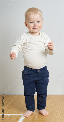 blonde scandinavian young boy in white and blue. estonian children at home