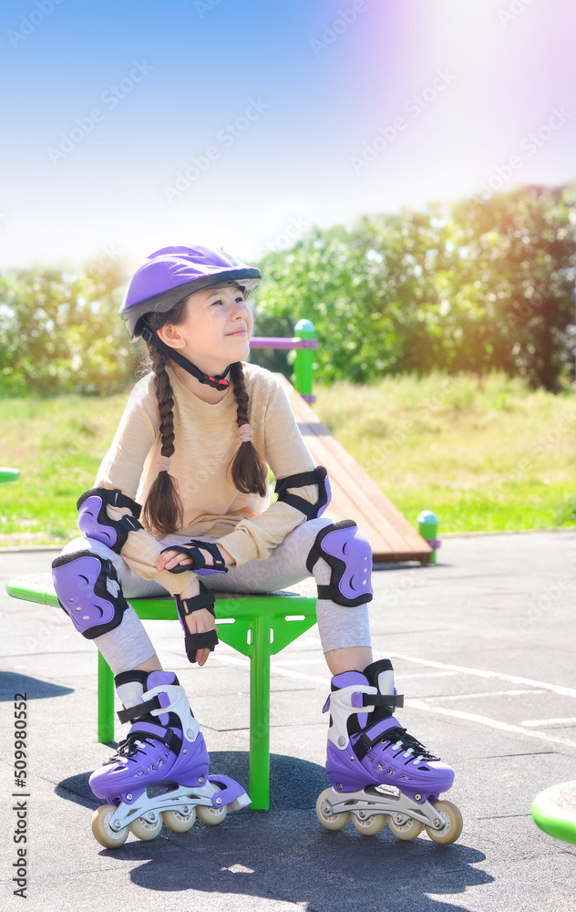 Φωτογραφία Portrait of a happy girl with roller skates, in a protective helmet, protective elbow pads on the background of a sports field