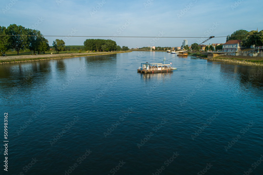 Aerial view of a passenger ferry boat crossing Drava river, Osijek, Croatia. Aerial view of a passenger ferry boat crossing Drava river, Osijek, Croatia.