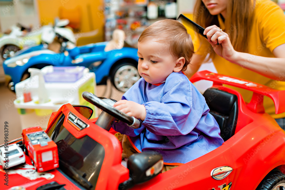 Baby's first haircut. Cute little boy at the professional children's hairdresser. Baby's first haircut. Cute little boy at the professional children's hairdresser.