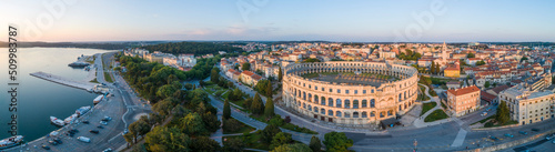 Panoramic aerial view of Pula arena and the harbour along the coast at sunset, Pula old town, Croatia.