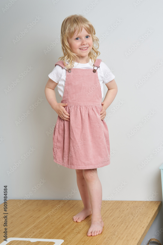 blonde scandinavian young girl in pink dress. estonian children at home blonde scandinavian young girl in pink dress. estonian children at home