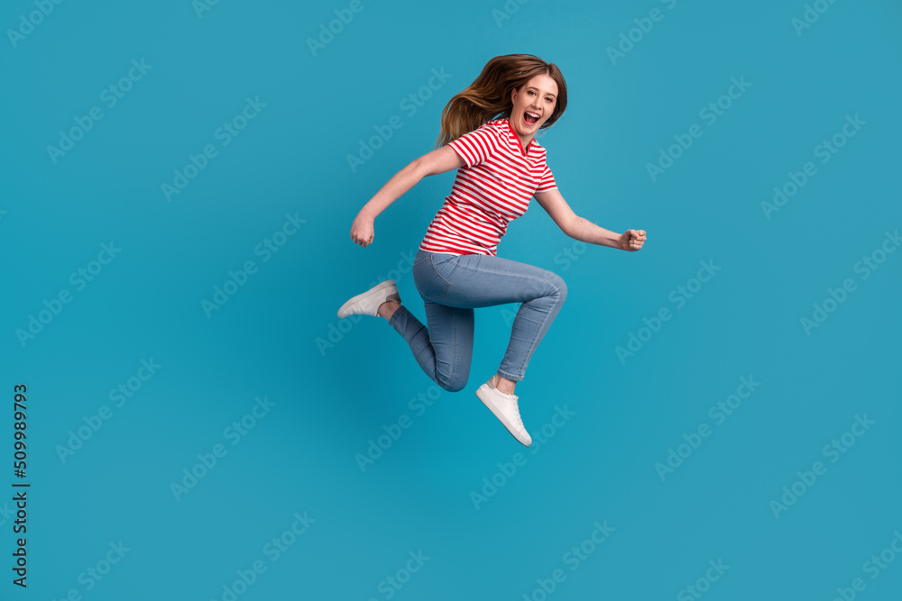 Full body profile side photo of young woman jump up runner hurry store isolated over blue color background