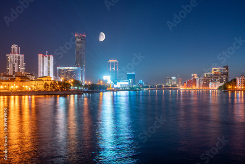 Night with big moon on a pond in the center of the city. Yekaterinburg city and pond at night.