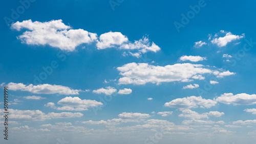 Blue sky, a cluster of clouds on a summer June day. Panoramic shot.