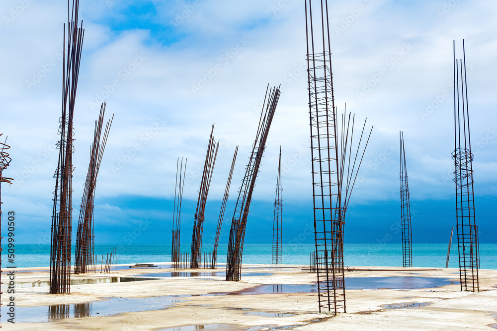 unfinished building with protruding rebar on the seashore