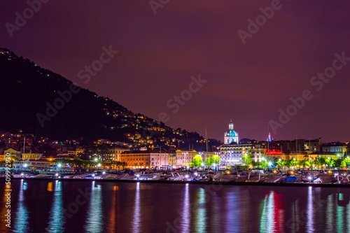 The city of Como, photographed in the evening, with the lakefront, the cathedral, and the surrounding mountains. 