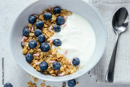 Yogurt with muesli and berries on a gray background.