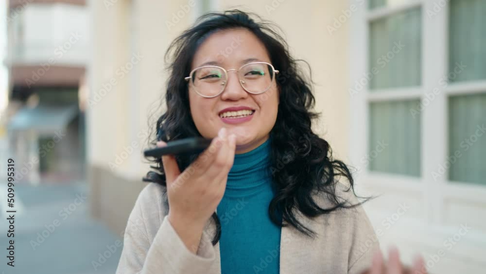 Young chinese woman smiling confident talking on the smartphone at street Young chinese woman smiling confident talking on the smartphone at street