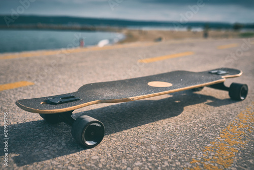 longboard on asphalt against the background of the sea without people photo