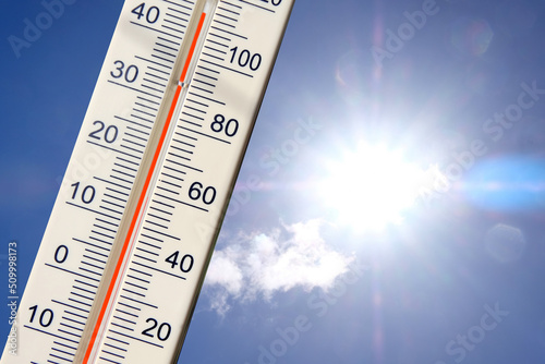 Thermomètre avec une double graduation degré centigrade et degré fahrenheit sur fond de ciel ensoleillé photo