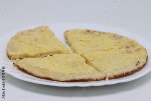 Pita warmed up with cheese lies on a plate, pita cut into pieces, proper nutrition, world food crisis. photo