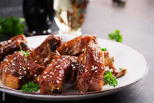 Billede på lærred Delicious barbecued spare ribs on plate on dark background