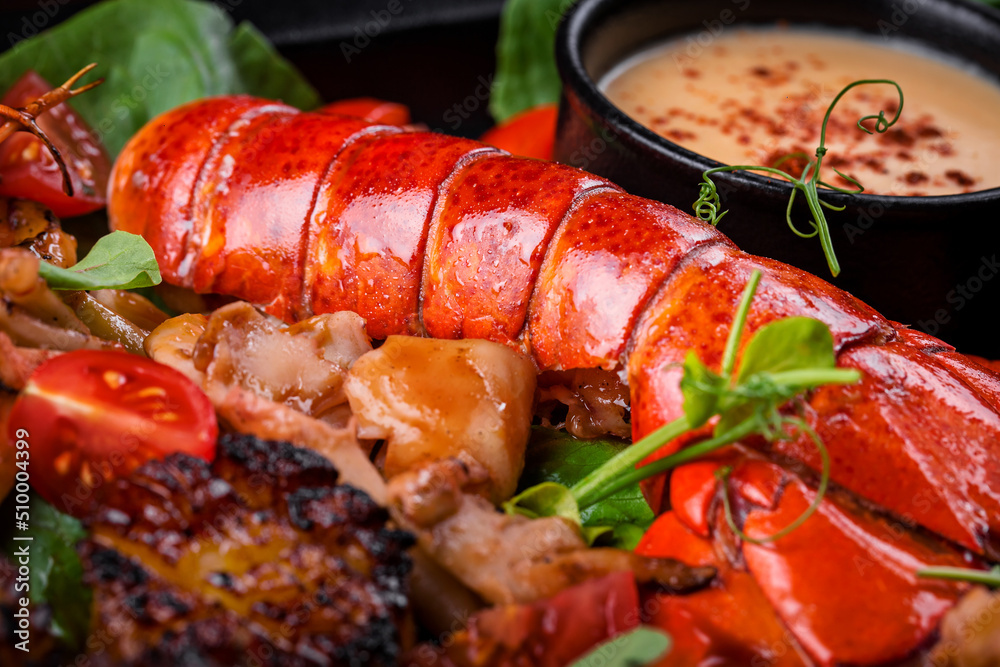 grilled lobster tail with seafood, tomato, microgreens and sauce 