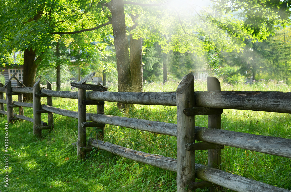 Old wooden fence on the meadow