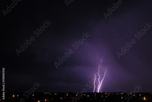 night city landscape with huge lightning in the night sky