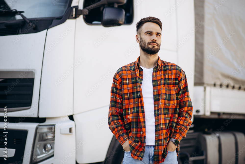 Man trucker smiling and standing by the lorry Man trucker smiling and standing by the lorry