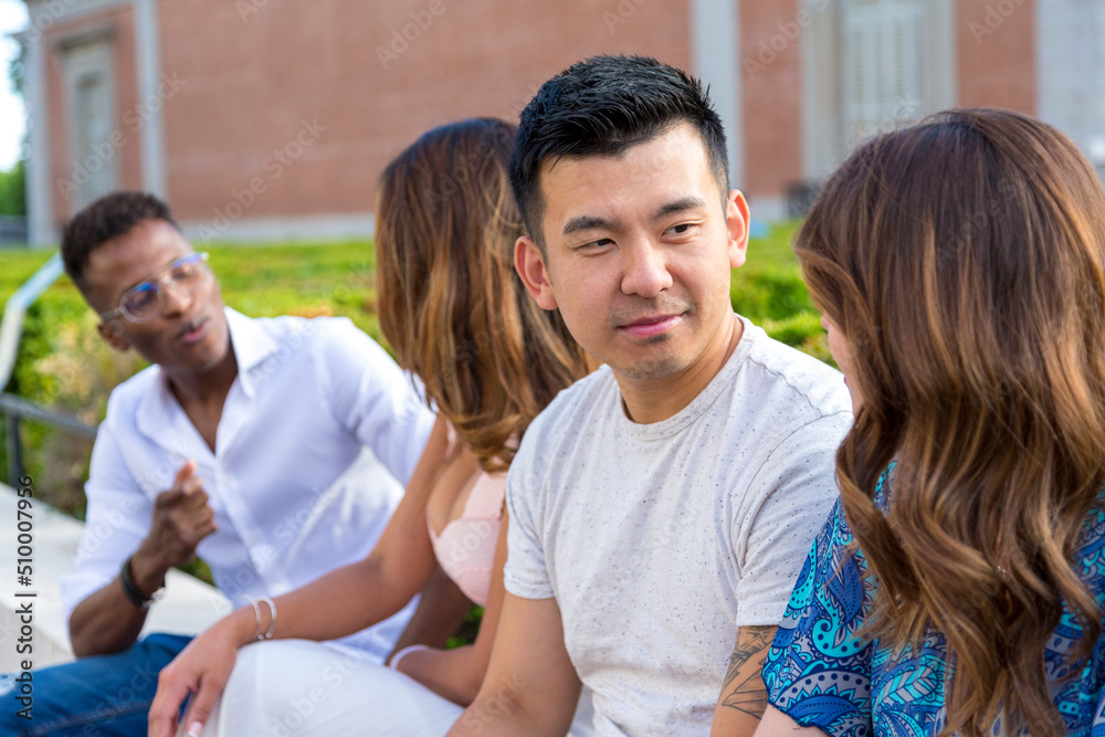 Fototapeta premium chinese young man with friends sitting outdoor