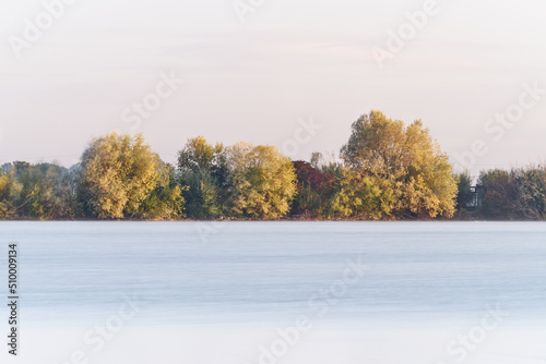 Fog over a lake with trees in the background near Erding, Germany