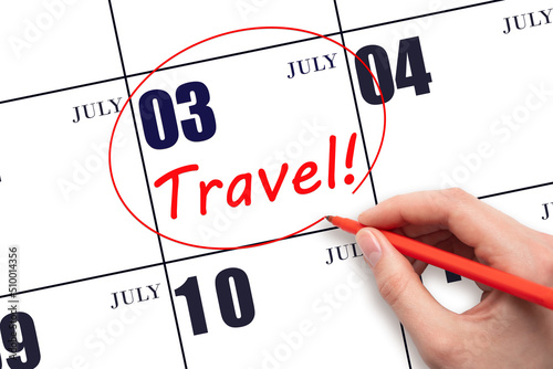 Hand drawing a red circle and writing the text TRAVEL on the calendar date 3July. Travel planning. photo