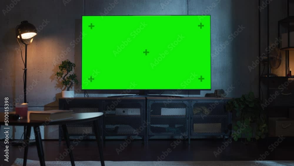 Zoom Out Shot of TV with Horizontal Green Screen Mock Up. Evening Living Room at Home with Chroma Key Placeholder on Monitor. No People Zoom Out Shot of TV with Horizontal Green Screen Mock Up. Evening Living Room at Home with Chroma Key Placeholder on Monitor. No People