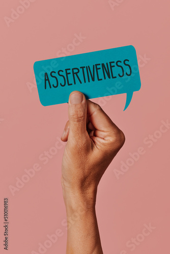 holds a sign with the text assertiveness photo