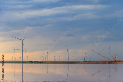 Building and assembling a construction wind turbines farm by a crane © olyasolodenko