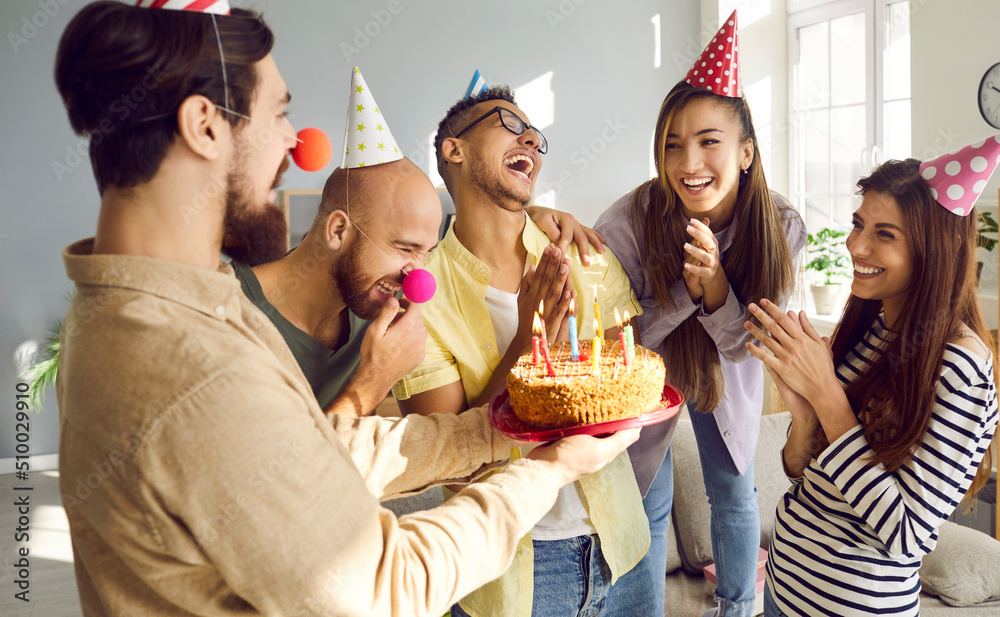 Smiling diverse people in festive cones congratulate excited girl with ...