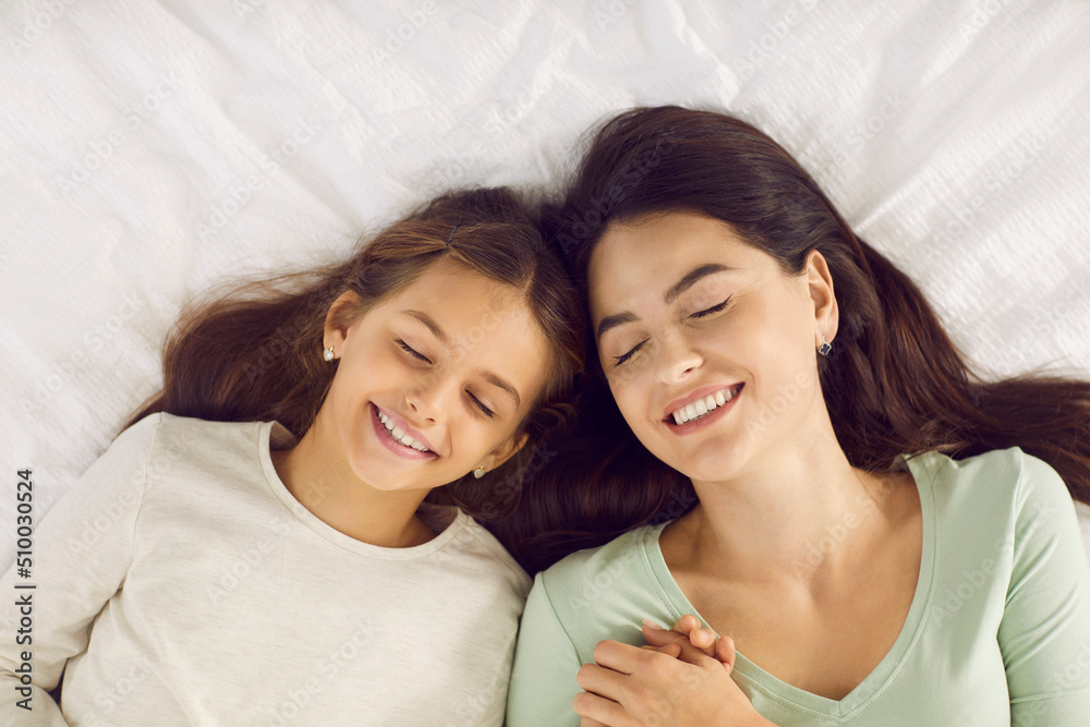 Happy family sleeping. High angle shot of a beautiful relaxed young mother together with her child resting on a soft white pillow on a warm, comfortable bed at home. Healthy sleep concept Happy family sleeping. High angle shot of a beautiful relaxed young mother together with her child resting on a soft white pillow on a warm, comfortable bed at home. Healthy sleep concept