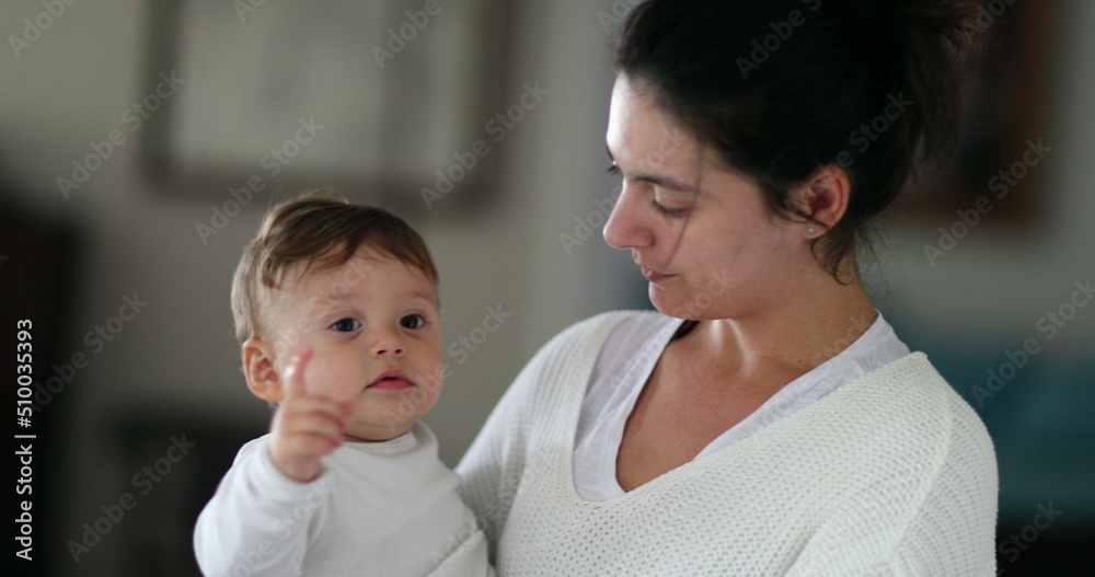 Casual family moment, mother holding infant baby boy in arms at home Casual family moment, mother holding infant baby boy in arms at home