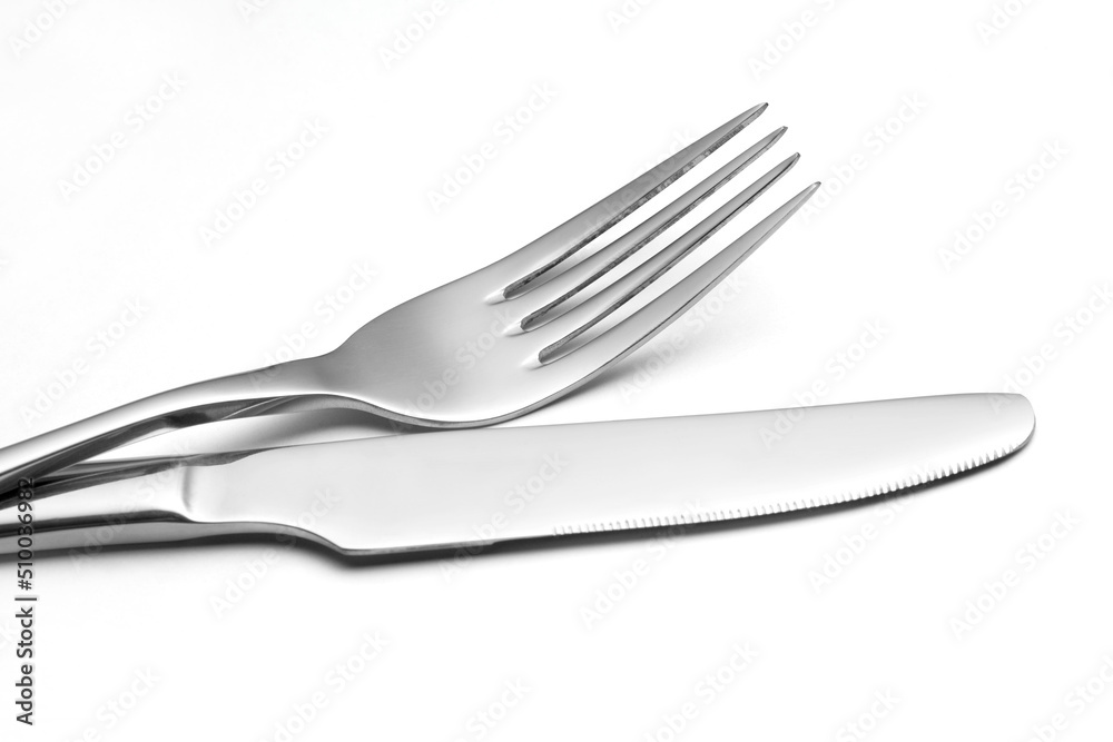 The metal shiny fork and knife on a white background. The metal shiny fork and knife on a white background.