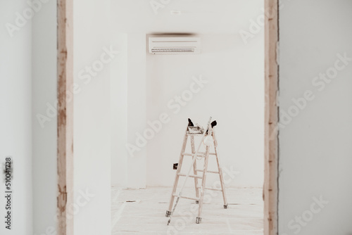 ladder on white room at construction site. Painting walls. Home improvement, renovation