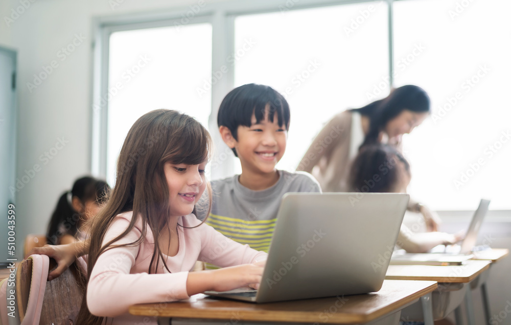 Diverse Multi ethnic of Little girl and boy using laptop Computers in classroom at Elementary school. Diverse Multi ethnic of Little girl and boy using laptop Computers in classroom at Elementary school.